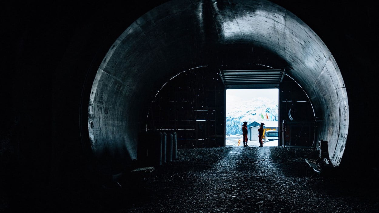 To mannlige fagarbeidere stående i en tunnelåpning
