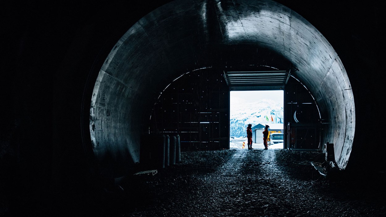 To mannlige fagarbeidere stående i en tunnelåpning